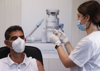 The Mayor of Naxos and Small Cyclades Dimitris Lianos waits to receive a first dose of the Pfizer-BioNTech vaccine against COVID-19 at a vaccination center on the Aegean island of Naxos, Greece, Tuesday, May 11, 2021. A vaccination program for Greek islands is being accelerated to cover all local residents by the end of June, the government has announced ahead of the launch of the tourism season. (AP Photo/Thanassis Stavrakis)