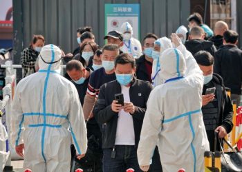 Workers in protective suits inspect the health information of passengers leaving Yantai Railway Station following the recent outbreak of the coronavirus disease (COVID-19), in Yantai, Shandong province, China November 2, 2021. China Daily via REUTERS  ATTENTION EDITORS - THIS IMAGE WAS PROVIDED BY A THIRD PARTY. CHINA OUT.