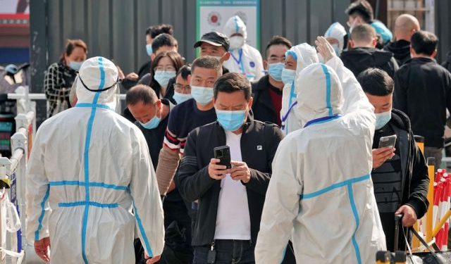 Workers in protective suits inspect the health information of passengers leaving Yantai Railway Station following the recent outbreak of the coronavirus disease (COVID-19), in Yantai, Shandong province, China November 2, 2021. China Daily via REUTERS  ATTENTION EDITORS - THIS IMAGE WAS PROVIDED BY A THIRD PARTY. CHINA OUT.