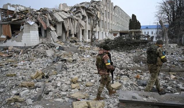 Ukrainian service members walk near a school building destroyed by shelling, as Russia's invasion of Ukraine continues, in Zhytomyr, Ukraine March 4, 2022. REUTERS/Viacheslav Ratynskyi
