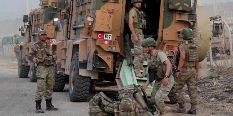 Turkish soldiers stand near military vehicles in the border town of Akcakale in Sanliurfa province, Turkey, October 11, 2019. REUTERS/Khalil Ashawi