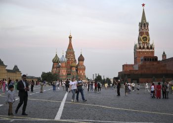 People stroll at the Red Square in Moscow, Russia, Tuesday, Aug. 1, 2023. The glittering towers of the Moscow City business district were once symbols of the Russian capital's economic boom in the early 2000s. Now they are a sign of its vulnerability, following a series of drone attacks that rattled some Muscovites shaken and brought the war in Ukraine home to the seat of Russian power. (AP Photo/Dmitry Serebryakov)