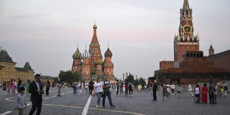 People stroll at the Red Square in Moscow, Russia, Tuesday, Aug. 1, 2023. The glittering towers of the Moscow City business district were once symbols of the Russian capital's economic boom in the early 2000s. Now they are a sign of its vulnerability, following a series of drone attacks that rattled some Muscovites shaken and brought the war in Ukraine home to the seat of Russian power. (AP Photo/Dmitry Serebryakov)