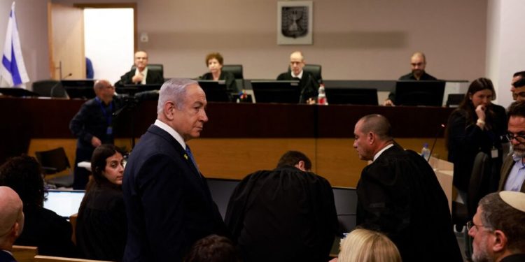 Israeli Prime Minister Benjamin Netanyahu enters the district court in Tel Aviv at the start of his hearing on corruption charges on December 10, 2024. Netanyahu, the first sitting prime minister of Israel to face a criminal trial, testified for the first time when his corruption case resumed on December 10 on charges of bribery, fraud and breach of public trust in three separate cases. (Photo by Menahem Kahana / POOL / AFP)